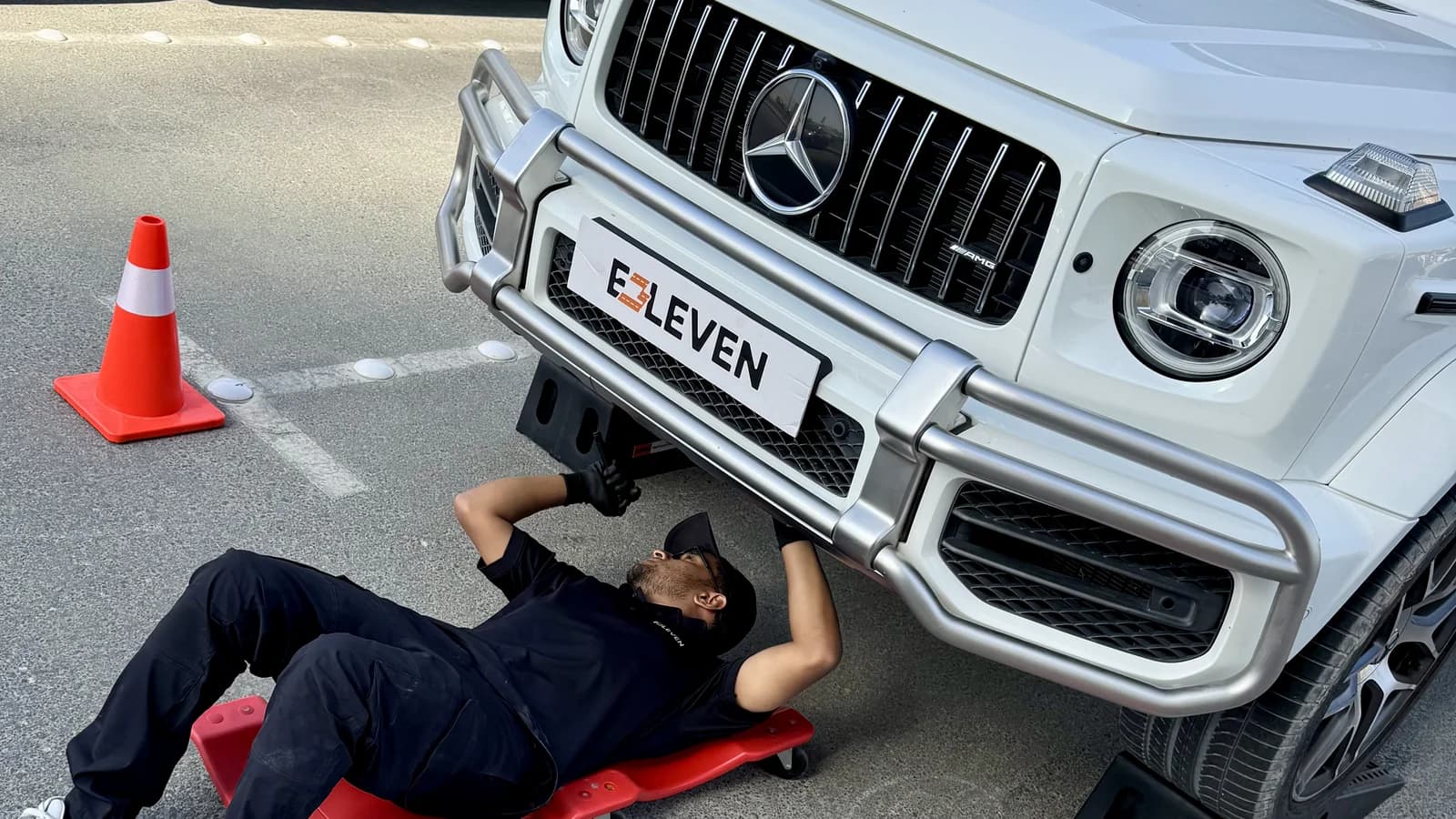 فني E3LEVEN يفحص أسفل السيارة في الموقع باستخدام رامات محمولة